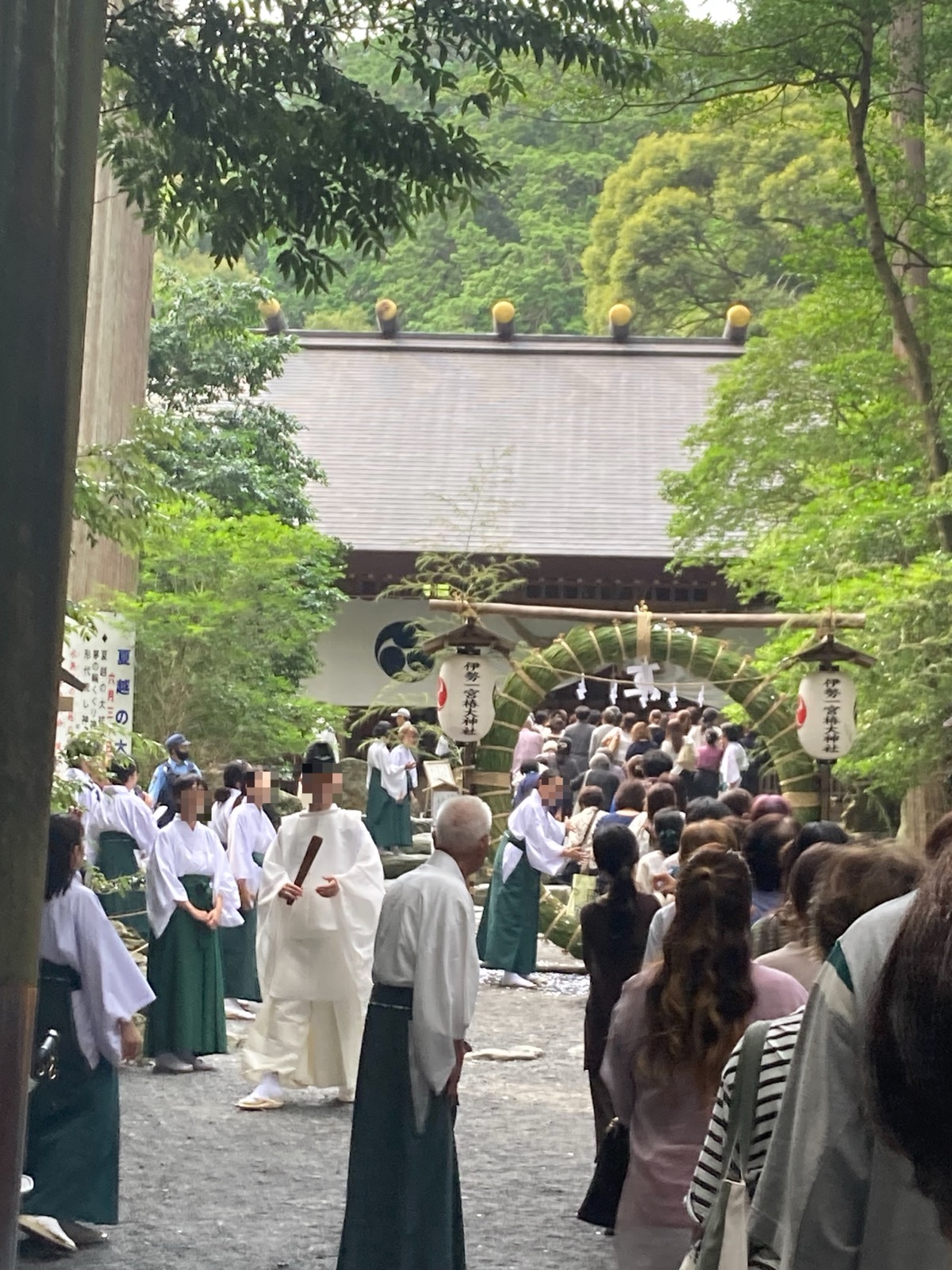 茅の輪の前に並ぶ神職と巫女、順番を待つ参拝者