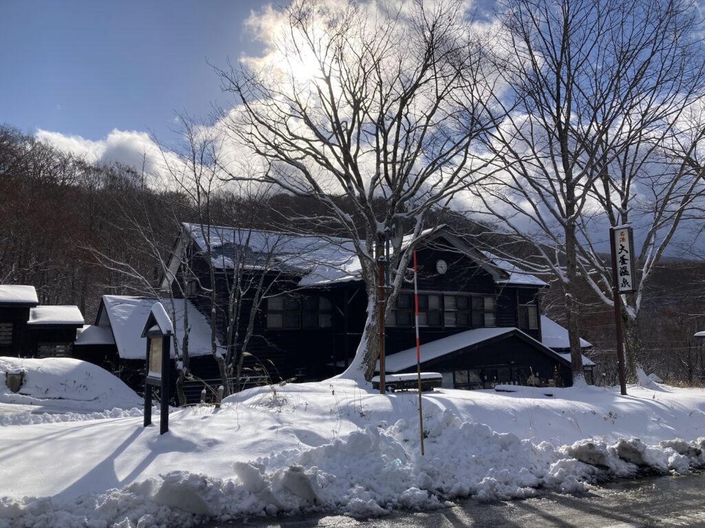 雪に囲まれた大釜温泉の建物と看板