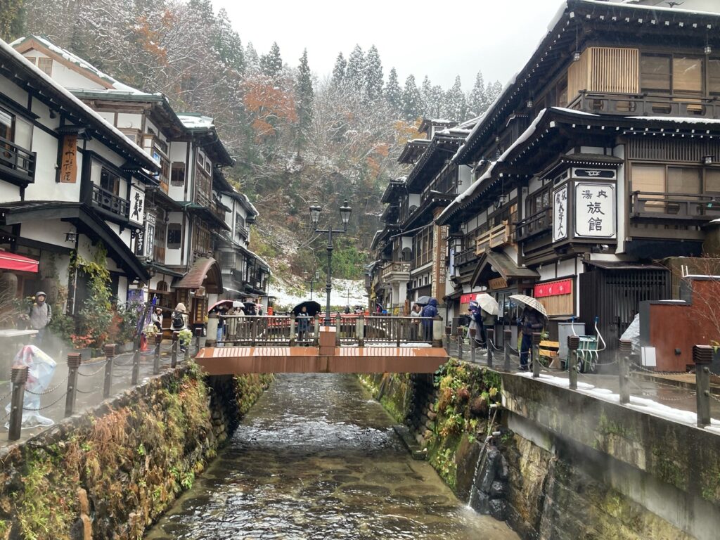 雪の銀山温泉の橋と、川沿いに並ぶ木造の旅館