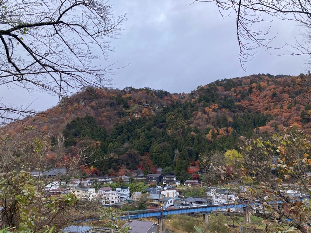 展望台から見た夕方の山寺と紅葉の山